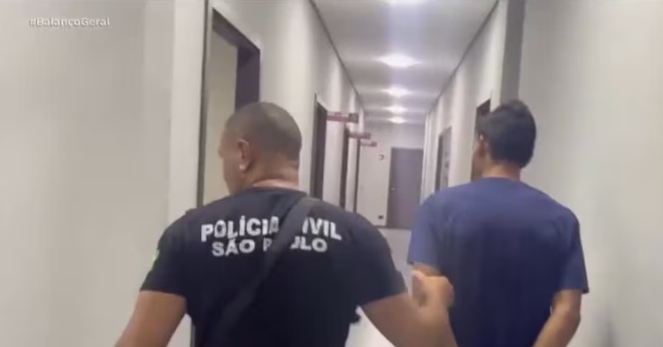 Imagem de policial civil conduzindo Maicol, suspeito de matar Vitória